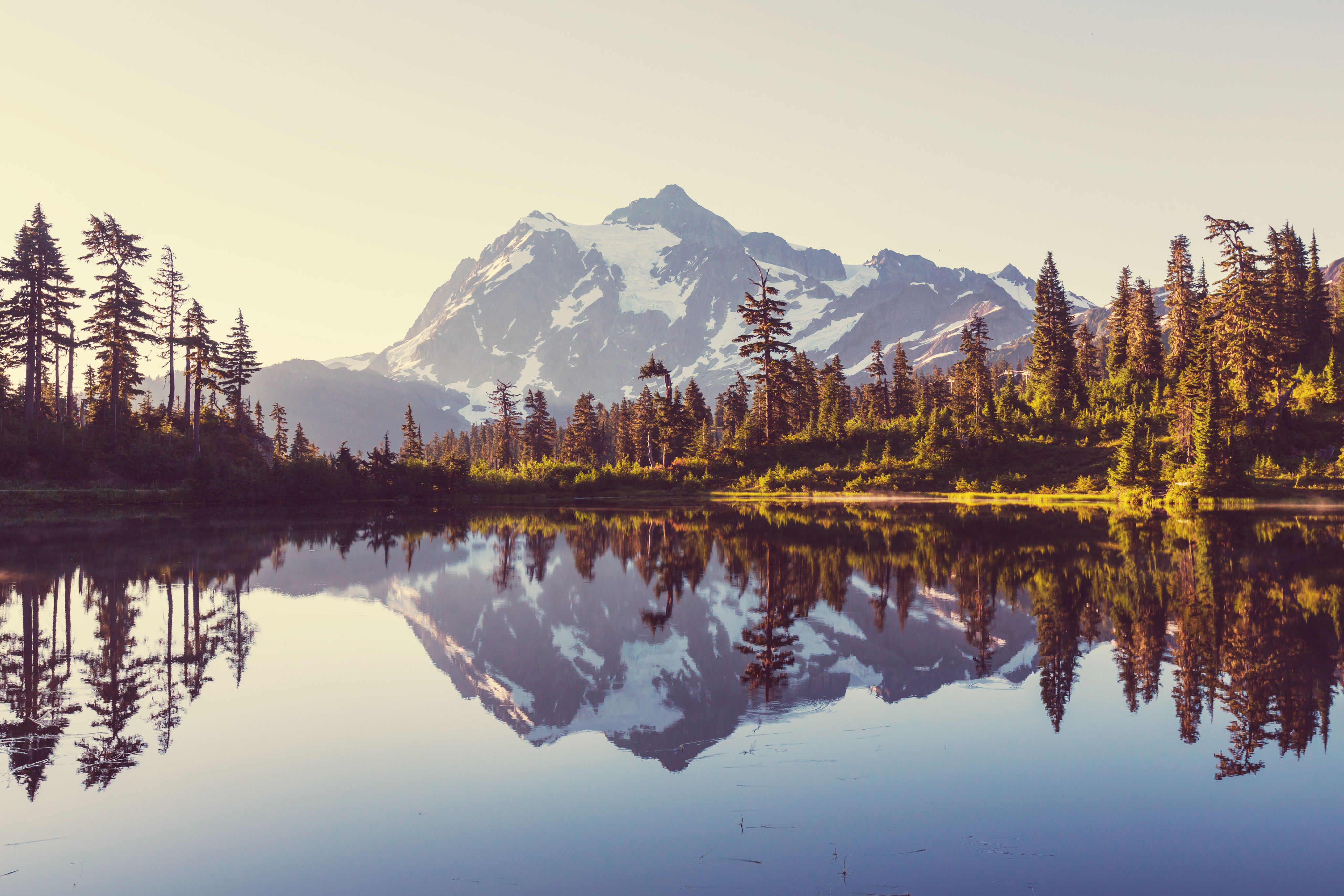 A snowy mountain peak reflected on a still lake